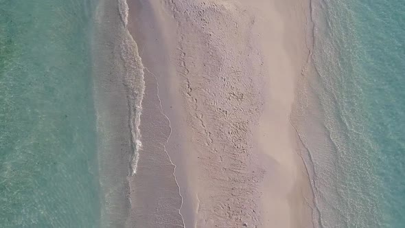 Aerial drone scenery of coast beach by blue water and sand background