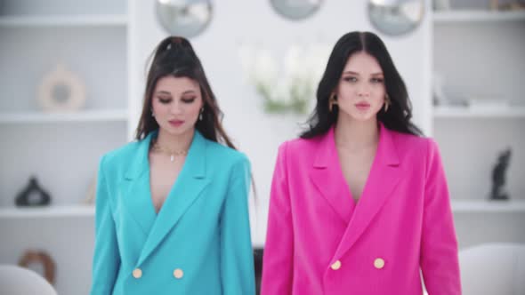 Two Fashionable Women in Pink and Blue Blazers Walks to the Camera