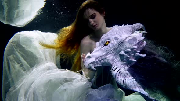 A Beautiful Mermaid Woman Swimming Underwater in an Elegant Dress Like in a Fairy Tale with a Dragon