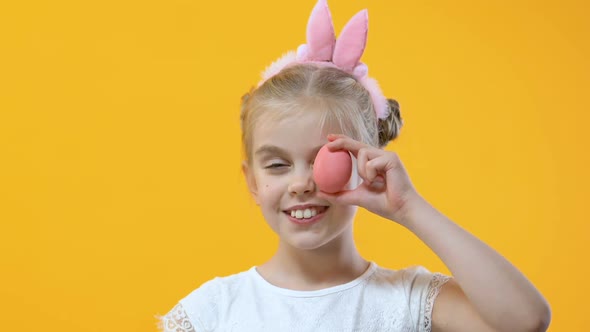 Child Having Fun Holding Colored Egg Near Eye