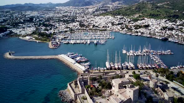 View from drone on full of yachts Bodrum harbour and ancient Kalesi castle in Mugla in Turkey