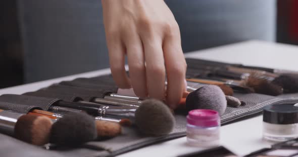 Professional Makeup Artist Selecting Right Makeup Brush From Set