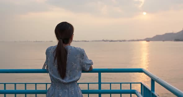 Woman look around the sea view at sunset