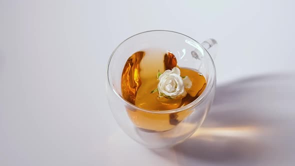 Glass Cup with Tea From Roses and a Natural Flower on a White Background Closeup