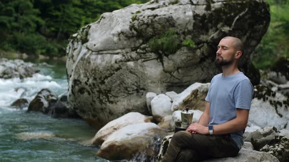 Peaceful man with close eyes enjoys nature and drinks coffee  from Mocha Pot