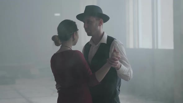 Portrait Man in Fedora Hat, Classical Suits and Woman in Style Cloth Dancing in Abandoned Building.