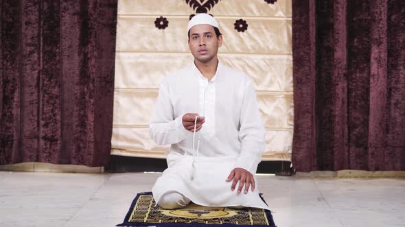 Muslim man praying beads