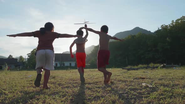 Happy Poverty Children Running And Playing With A Cardboard Airplane