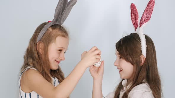 Two Girls Friends in Bunny Ears Holding Easter Eggs on Holiday