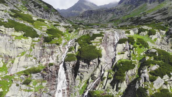 Flying over Waterfall to Mountains in High Tatras in Slovakia