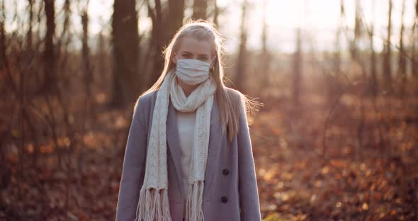 Woman Putting on Protective Mask Against Coronavirus alt