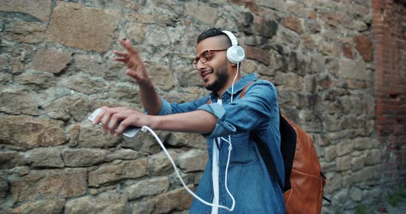 Slow Motion of Joyful African American Guy Listening To Music in Headphones