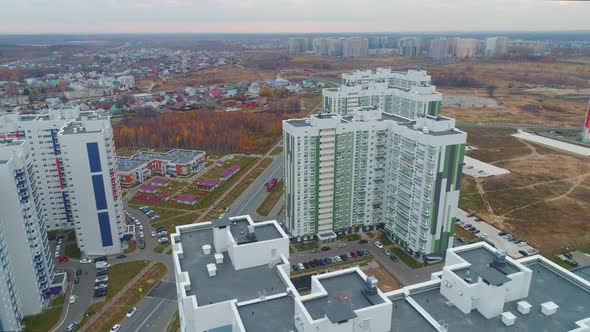 High Apartment Buildings with Color Decor and Autumn Park