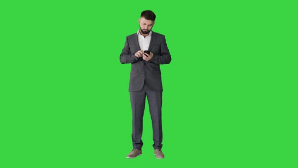 Turk Business Man Texting on His Phone on a Green Screen, Chroma Key.