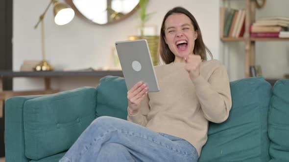 Success, Young Woman Celebrating On Tablet on Sofa 