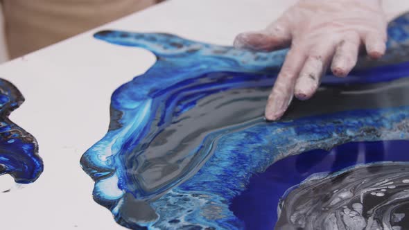Smearing Dark Blue Epoxy Resin on the Painting with a Finger
