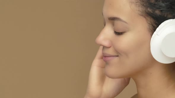 Beauty Portrait of Young African American Woman Dancing and Enjoying Music in Big White Headphones