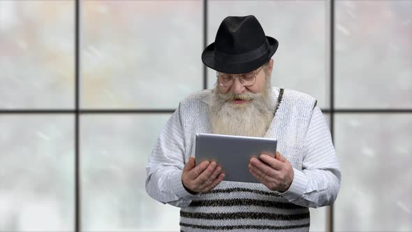 Senior Man Talks Via Tablet Computer