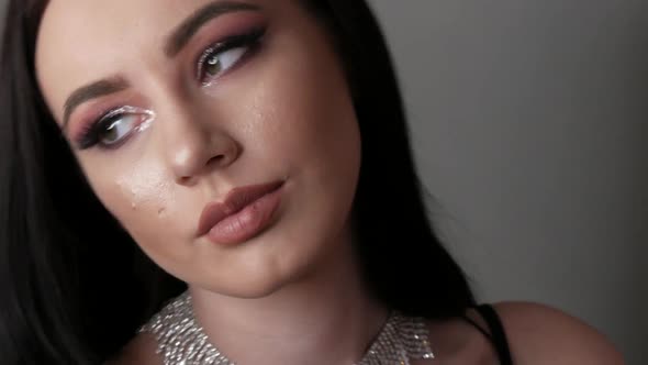 Young Woman with Beautiful Bright Evening Makeup Posing in Studio