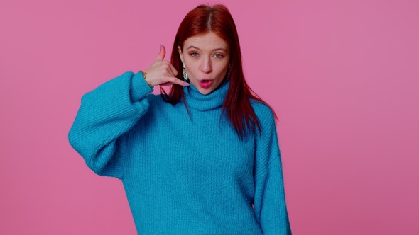 Cheerful Girl in Blue Sweater Looking at Camera Doing Phone Gesture Like Says Hey you Call Me Back