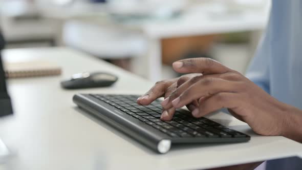 Hands of African Man Typing on Keyboard Close Up