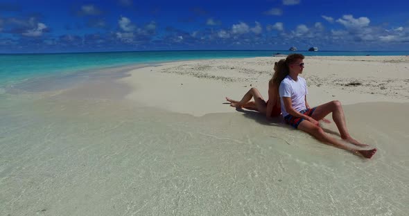 Beautiful boy and girl on romantic honeymoon spend quality time on beach on paradise white sand back