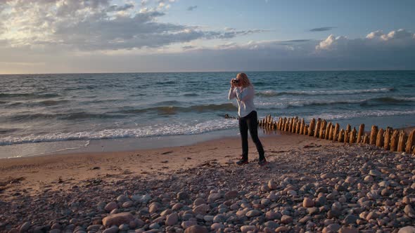 Photographer Using Slr Camera On Sunlit Beach