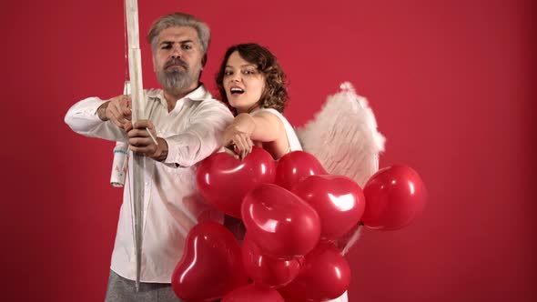 Romantic Angels Couple Aiming with Bow, Arrow and Wings. Valentine's Day Ideas. Red Heart. Dating