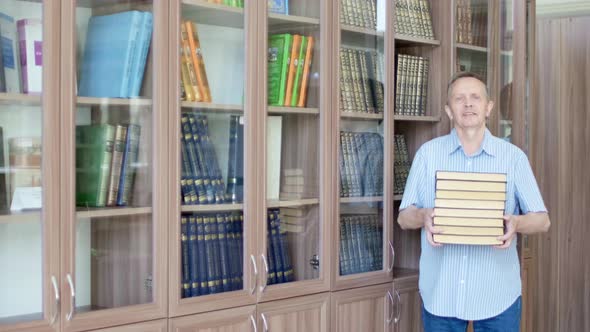 Senior Man with Mustache Carrying Lots of Books