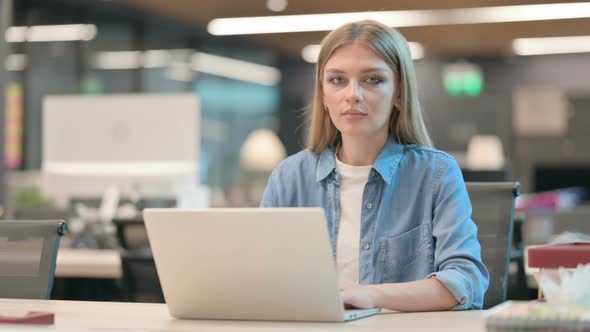 Young Woman with Laptop Smiling at Camera