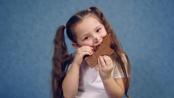 Portrait of a little girl eating chocolate. 