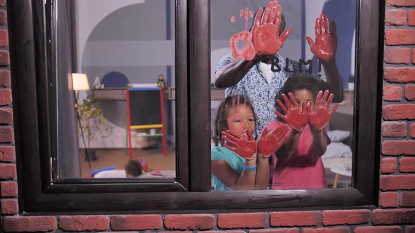 Black Family Making Blood Red Handprints on Window