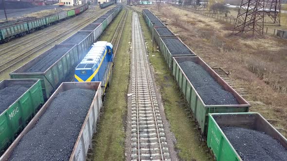 Long row of train cargo cars loaded full with fossil fuel coal.