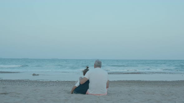 A Man and a Boy are Sitting on the Shore