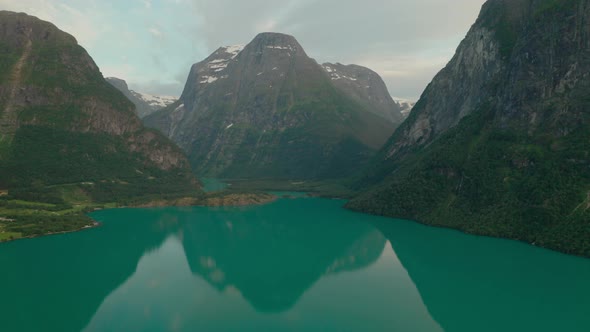 Turquoise Blue Waterscape Of The Lake Surrounded With Mountain Range In Stryn, Norway. aerial