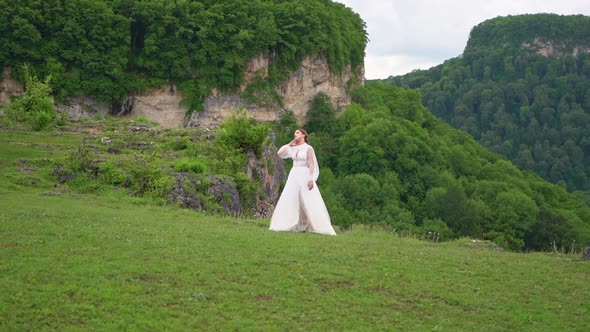 A Woman in a Wedding Dress and Black Boots Posing in the Mountains