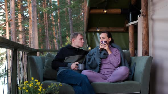 Man and Woman Drinking Tea While Luxury Camping