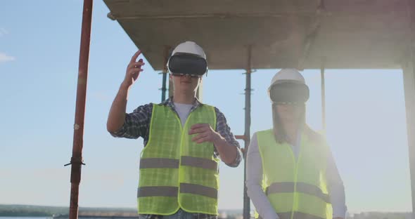 Construction Site Team or Architect and Builder or Worker with Helmets Discuss on a Scaffold