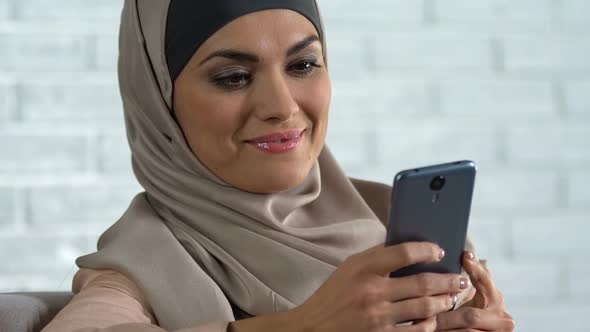 Attractive Arab Woman Scrolling Social Networks on Smartphone, Modern Technology