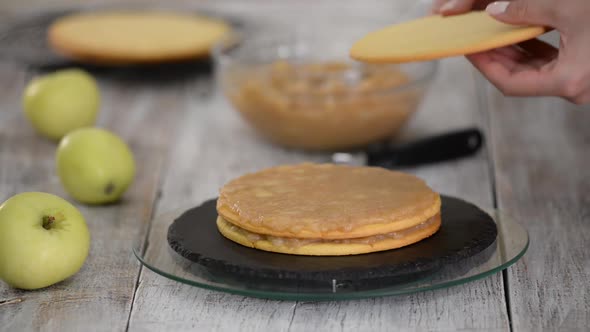 Cook Making Layer Cake with Apple Filling.