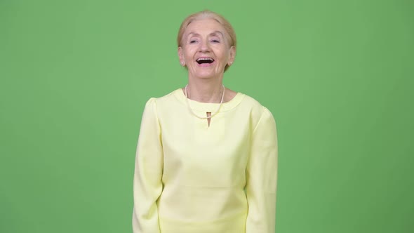 Studio Shot of Happy Senior Businesswoman Smiling and Thinking