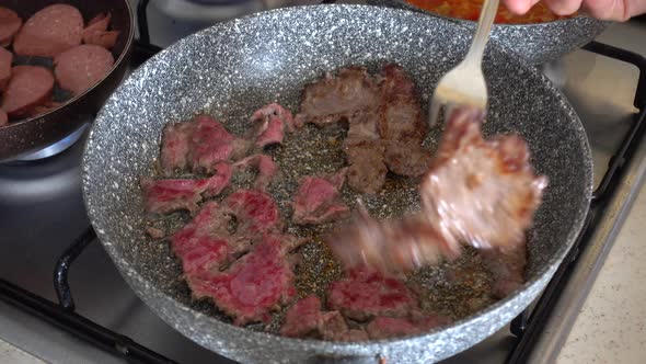 Sausage and beef cutlet cooked in a pan on the stove, breakfast preparation, breakfast preparation a