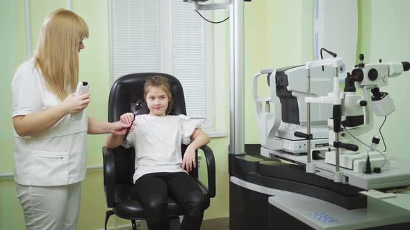an Ophthalmologist Diagnoses a Little Girl's Vision on a Sign Projector