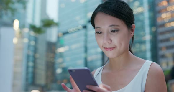 Woman use of cellphone in the city at night