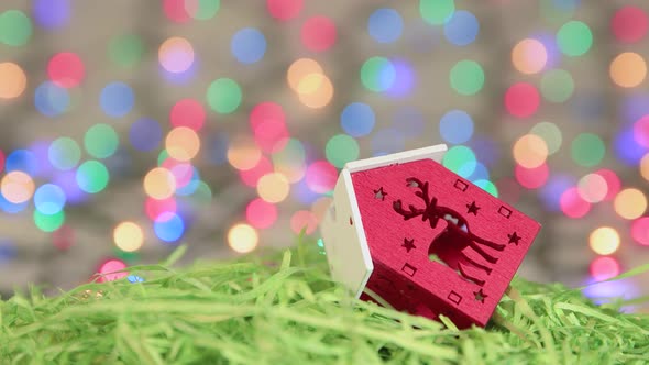 Red Christmas House on Green Tinsel Christmas Background Copy Space