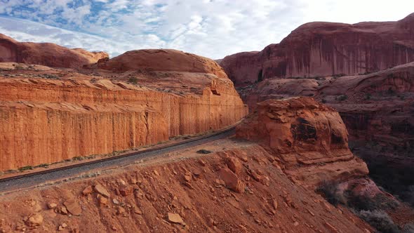 Aerial view over rail road through stunning arches National Park in Utah on sunny day. Curvy rail tr