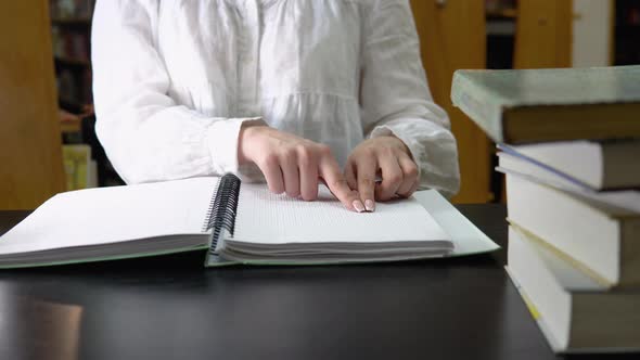 Blind Girl Reading a Text of Braille in Library