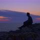 Young Man Sitting, Waits for the Sunrise at the Sea in a Blue Hour. General View - VideoHive Item for Sale