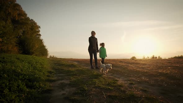 Woman with Little Daughter Walking the Dog in the Park Forest