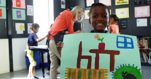 Portrait of happy girl showing her painting in drawing class